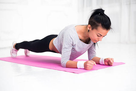 sporty fit sliming girl doing plank exercise in yoga class. fitness, home and diet concept
